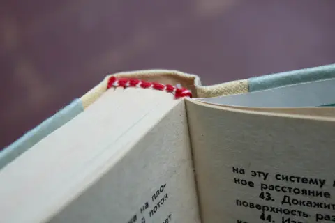 Красная нитяная прошивка в корешковом сгибе учебника физики