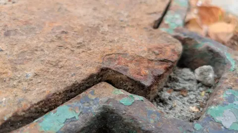 Слоистая ржавчина на сколотой кромке крышки