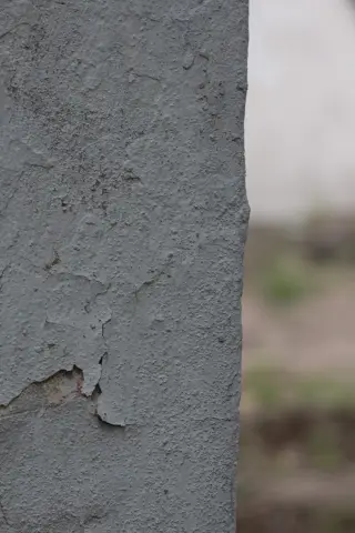 Шероховатая серая кромка бетонной колонны