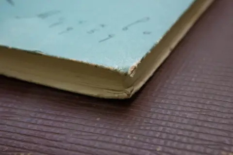 Потёртый угол сине-зелёной книжной обложки